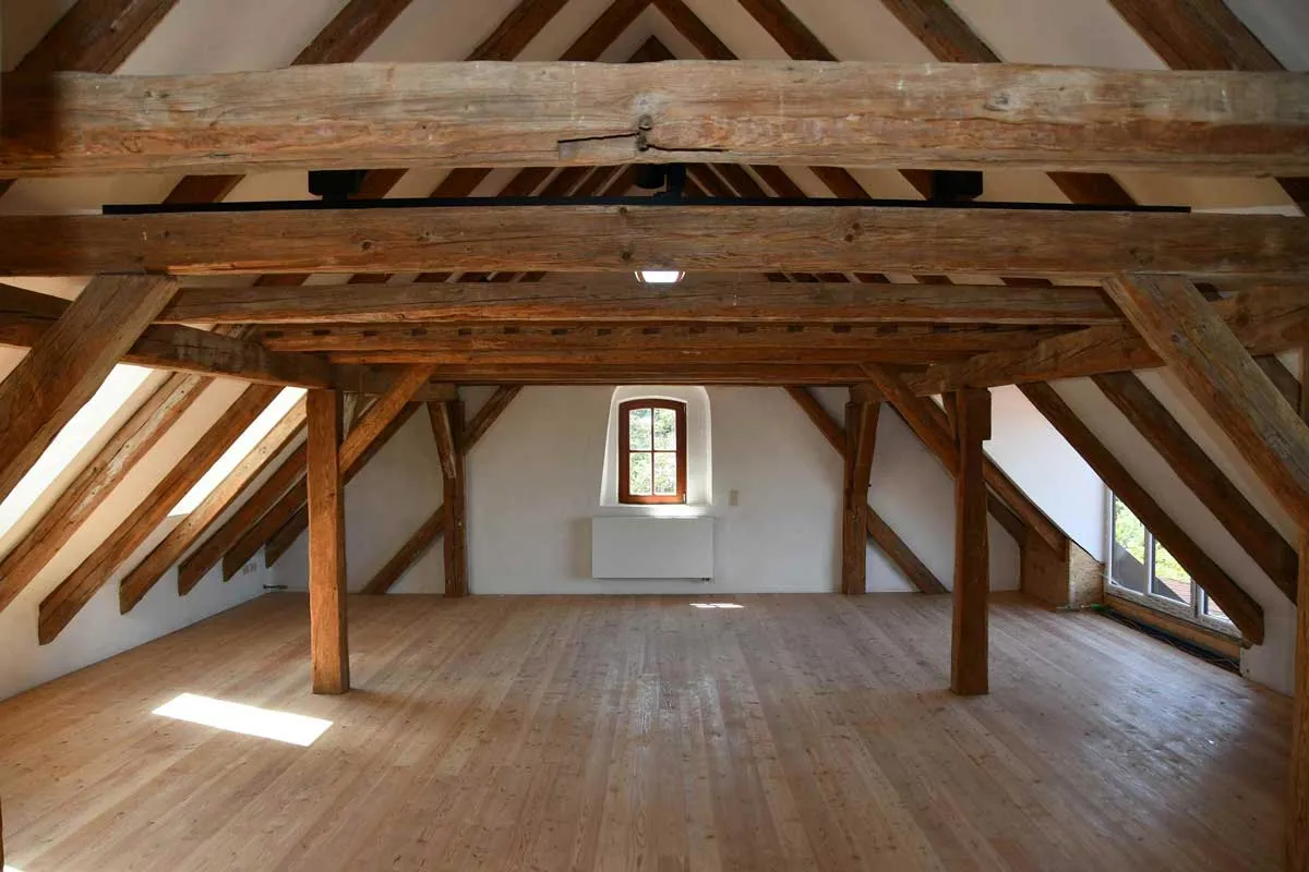 Seminarraum unter dem Dach des Großwiesenhofs mit alten Holzbalken und Dielenboden